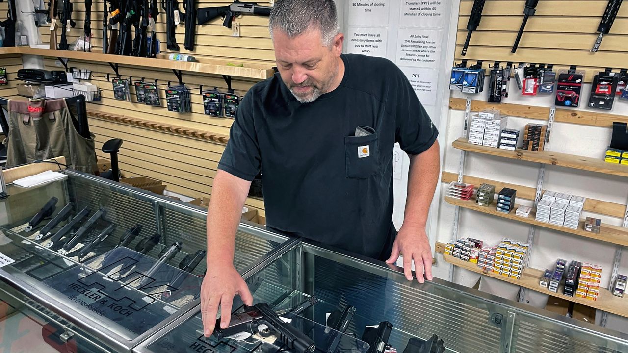  John Parkin, co-owner of Coyote Point Armory displays a handgun at his store in Burlingame, Calif., June 23, 2022. In response to the U.S. Supreme Court's ruling that allows more people to carry concealed weapons, California lawmakers, on Tuesday, June 28, 2022, moved to boost requirements and limit where firearms may be carried while staying within the high court's ruling. (AP Photo/Haven Daley, File)