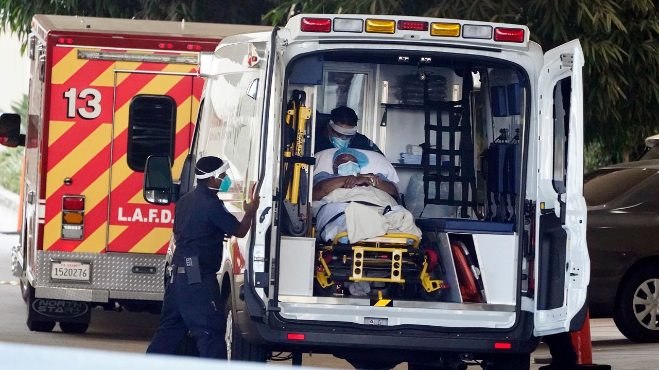 A patient is loaded onto an ambulance outside of the emergency entrance to PIH Health Good Samaritan Hospital Tuesday, Jan. 5, 2021, in Los Angeles. (AP Photo/Marcio Jose Sanchez)