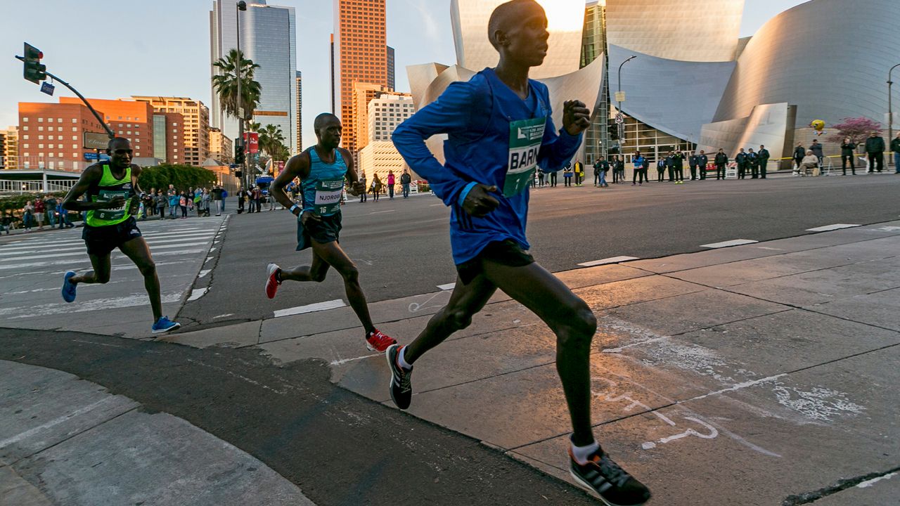 Los Angeles Marathon Elite runners, from left, Weldon Kirui, Simon Njoroge, Elisha Barno race past the Walt Disney Concert Hall in Los Angeles Sunday, March 18, 2018. (AP Photo/Damian Dovarganes)