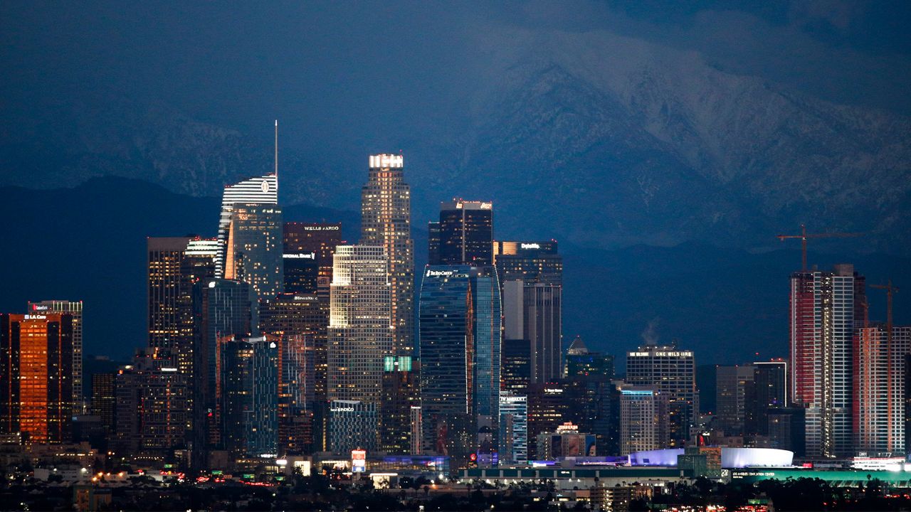 Snow-capped mountains are seen behind the Los Angeles' downtown skyline at dusk Thursday, Feb. 21, 2019, in Los Angeles. (AP Photo/Jae C. Hong)