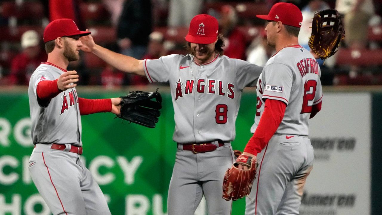 Los Angeles Angels' Taylor Ward, celebrates a 5-1 victory over the Cardinals with teammates Brett Phillips (8) and Hunter Renfroe (12) following a baseball game Tuesday in St. Louis. (AP Photo/Jeff Roberson)