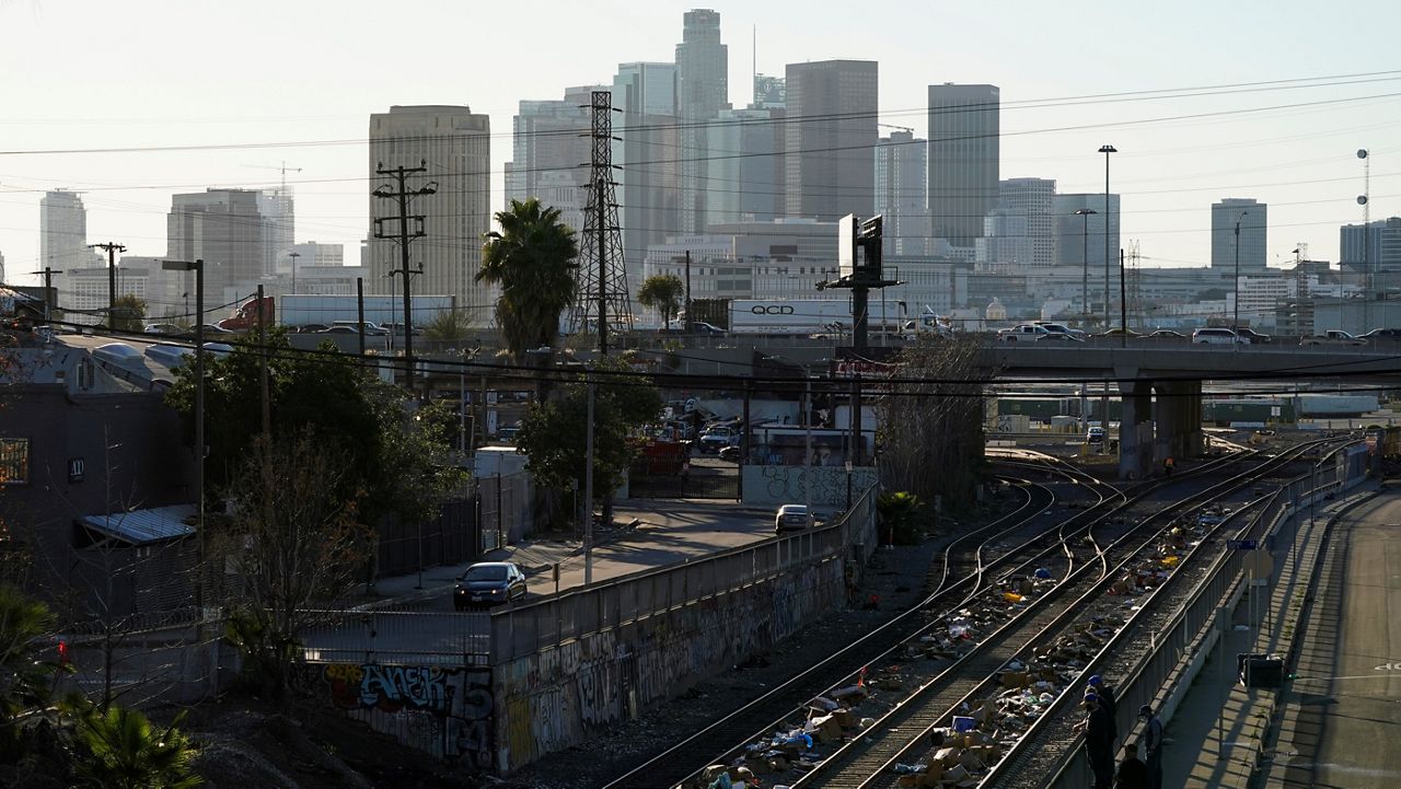 Men look over a railing at a Union Pacific railroad site on Thursday, Jan. 20, 2022, in Los Angeles. (AP Photo/Ashley Landis)