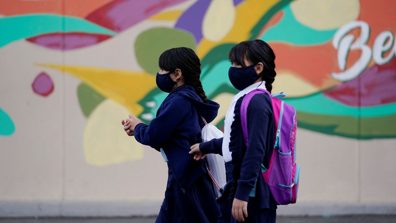 Students walk to class amid the COVID-19 pandemic at Washington Elementary School Wednesday, Jan. 12, 2022, in Lynwood, Calif. (AP Photo/Marcio Jose Sanchez)