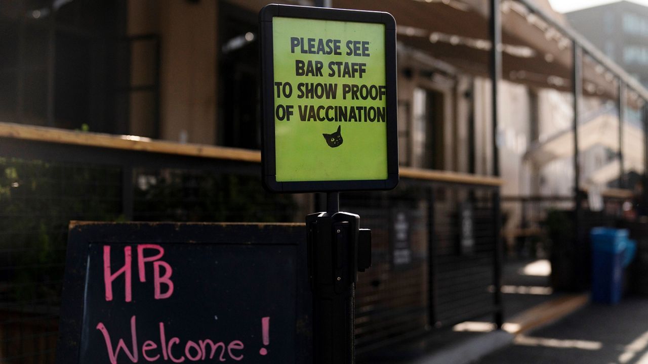 A sign asking customers to show proof of COVID-19 vaccination stands outside Highland Park Brewery Monday, Nov. 8, 2021, in Los Angeles. (AP Photo/Jae C. Hong)