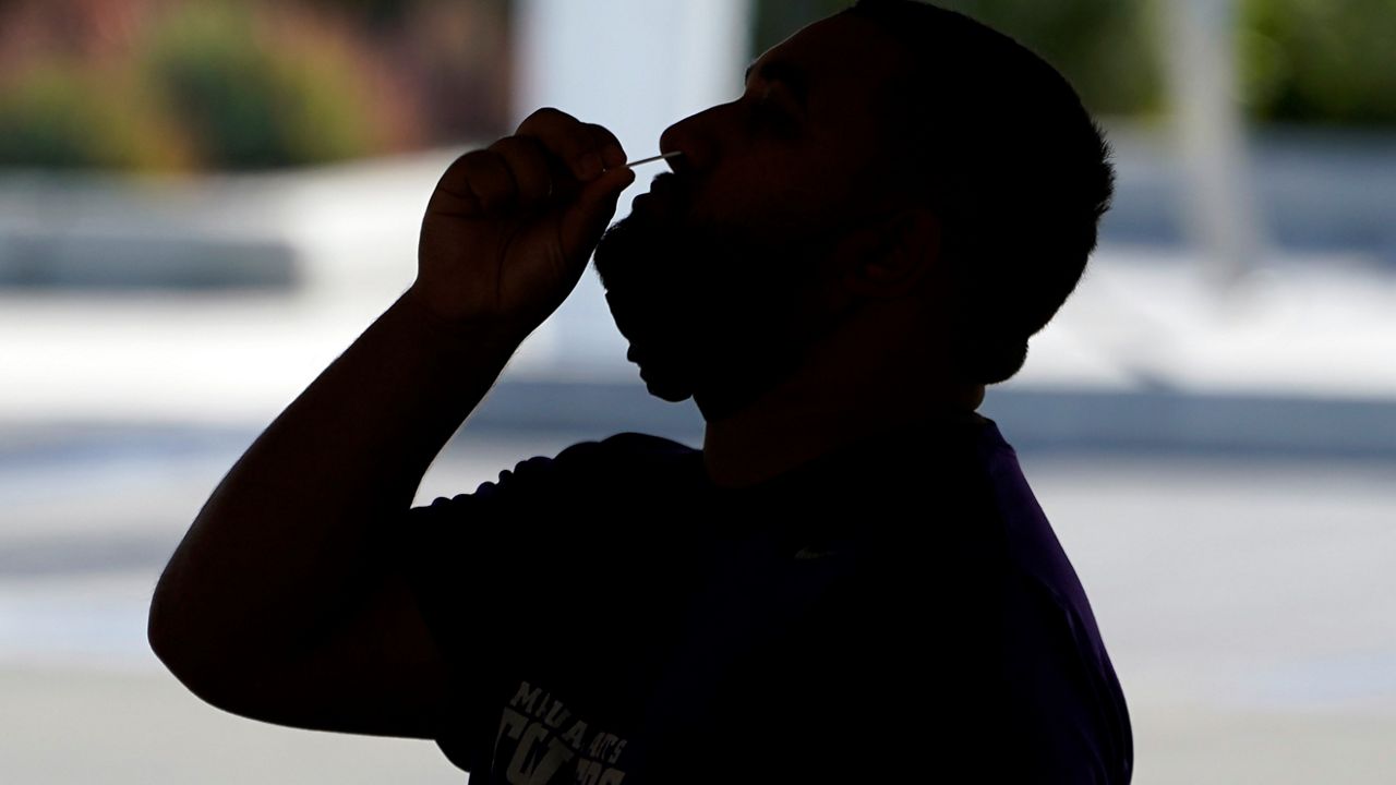 A man swabs his nose at a COVID-19 testing on the Martin Luther King Jr. medical campus Monday, Jan. 3, 2022, in Los Angeles. (AP Photo/Marcio Jose Sanchez)