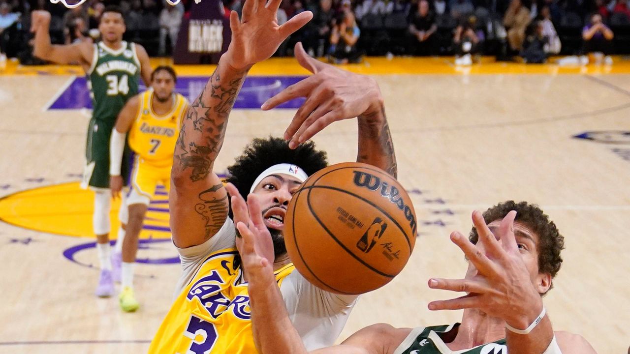 Los Angeles Lakers forward Anthony Davis, left, and Milwaukee Bucks center Brook Lopez go after a rebound during the second half of an NBA basketball game Thursday in LA. (AP Photo/Mark J. Terrill)