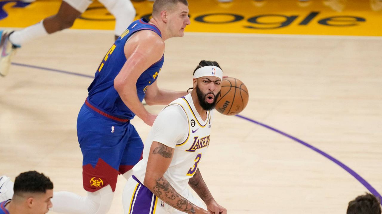 Los Angeles Lakers forward Anthony Davis (3) reacts after scoring past Denver Nuggets center Nikola Jokic, left, in the first half of Game 3 of the NBA basketball Western Conference Final series Saturday in LA. (AP Photo/Ashley Landis)