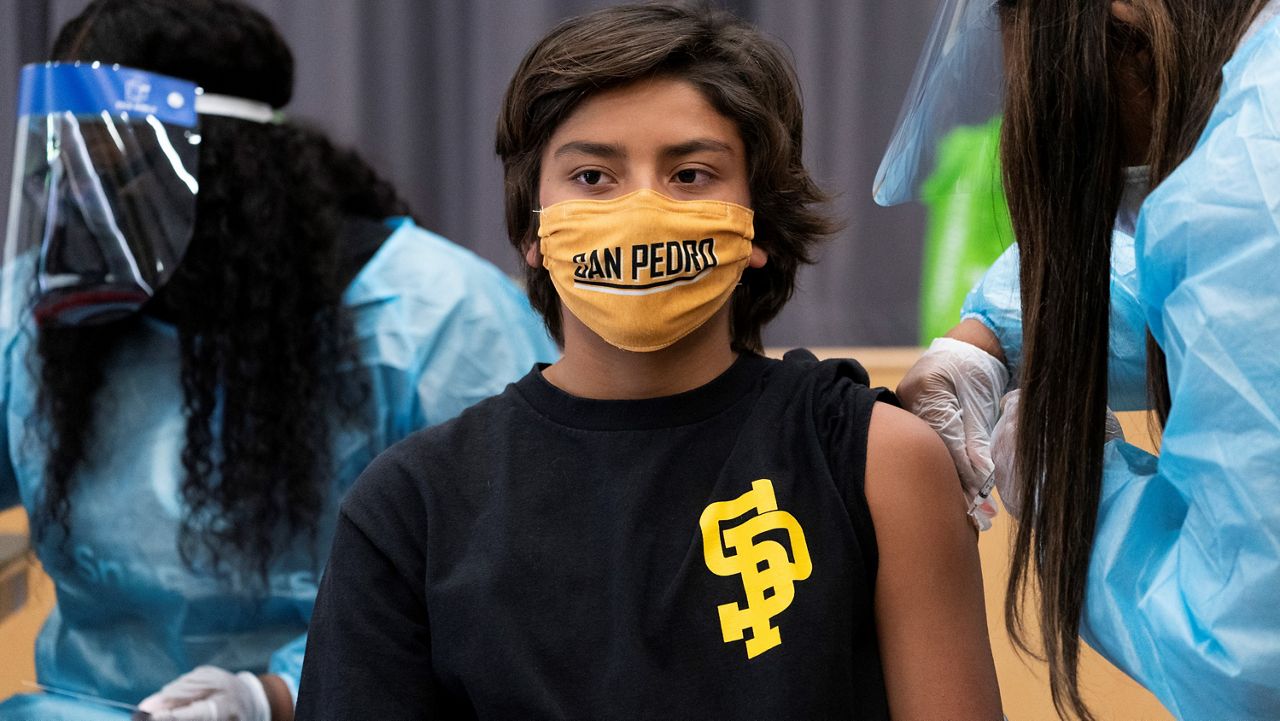 In this Monday, May. 24, 2021, photo high school student Alex Bugarin, 13, is vaccinated at a school-based COVID-19 vaccination clinic for students 12 and older at the LAUSD San Pedro High School John M. and Muriel Olguin Campus in San Pedro, Calif. (AP Photo/Damian Dovarganes)