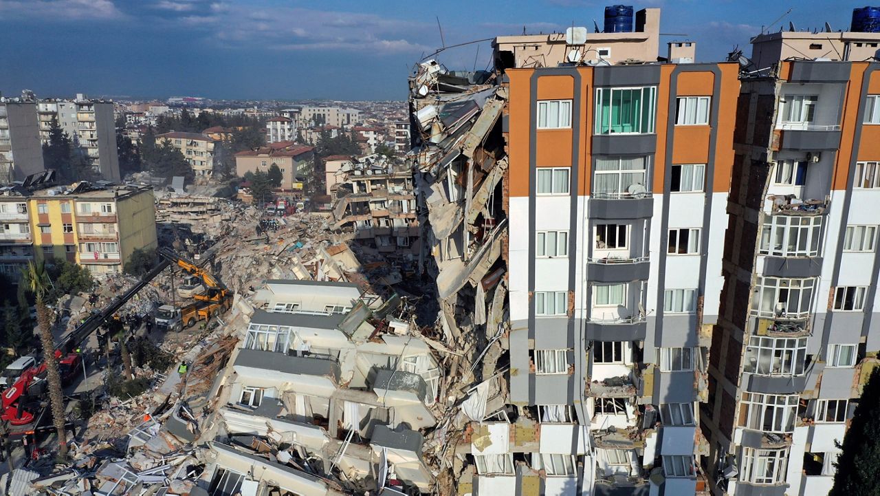 Cranes remove debris next to destroyed buildings in Antakya, southeastern Turkey, Friday, Feb. 10, 2023. (AP Photo/Hussein Malla)