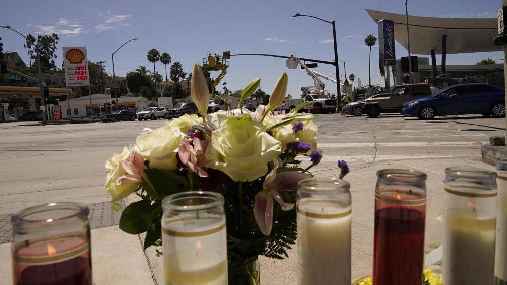 Flowers and candles are left on an intersection after after crash involving as many as six cars near a gas station in the unincorporated Windsor Hills in Los Angeles, Friday, Aug. 5, 2022. A speeding car ran a red light and plowed into cars in a crowded intersection Thursday in a fiery crash that killed several people, including a baby, just outside of Los Angeles, authorities said. (AP Photo/Damian Dovarganes)