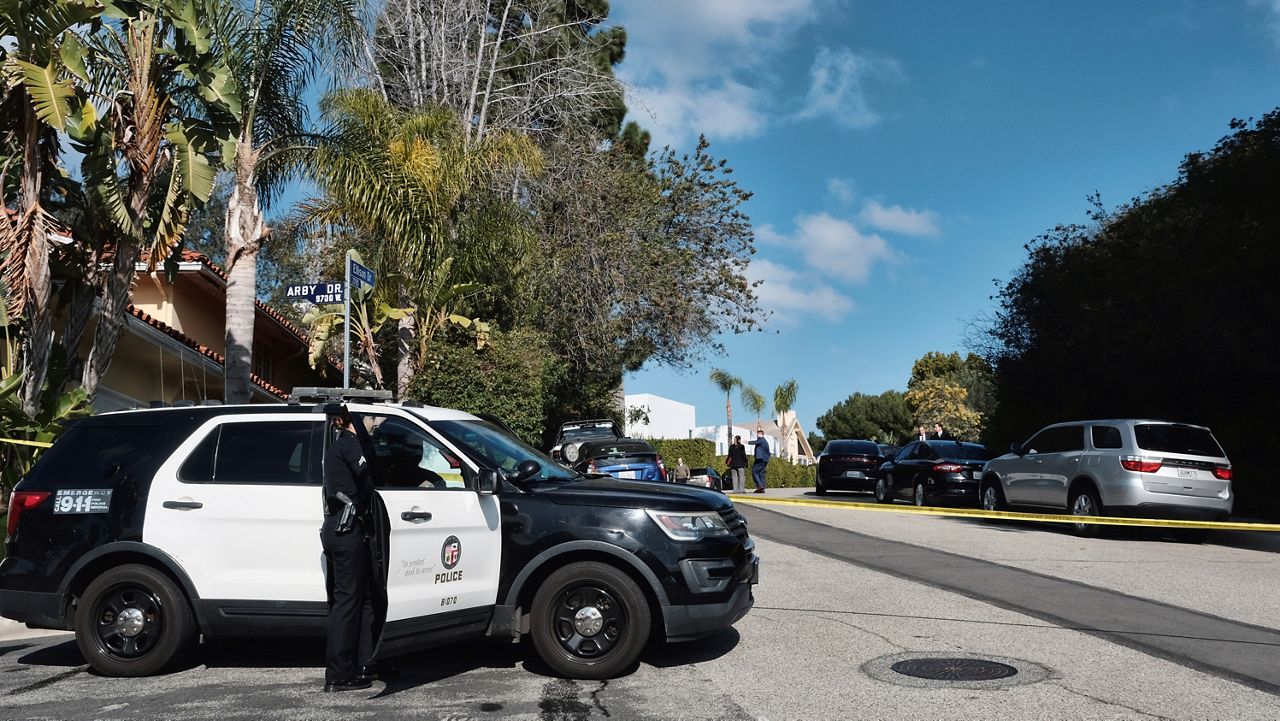Police block a street to a house where three people were killed and four others wounded in a shooing at a short-term rental home in an upscale Los Angeles neighborhood on Saturday Jan. 28, 2023. (AP Photo/Richard Vogel)
