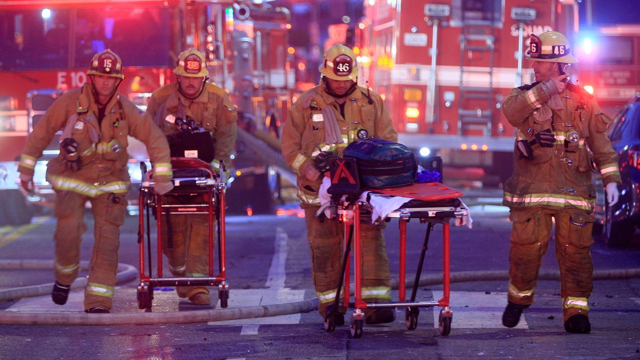 LAFD firefighters push gurneys at the scene of a structure fire that injured multiple firefighters on May 16, 2020. (AP Photo/Damian Dovarganes)