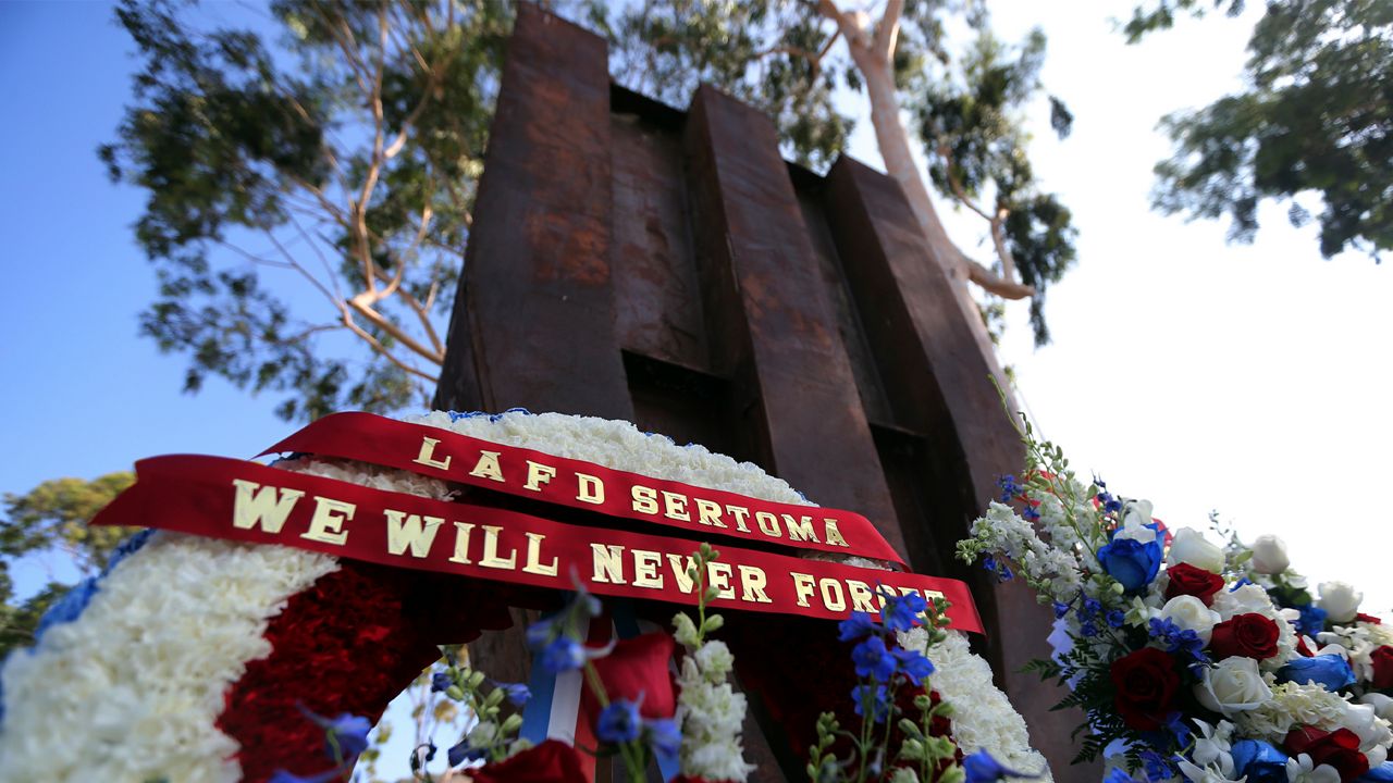 A wreath with the words "We Will Never Forget" is seen during a ceremony marking the 17th anniversary of the Sept. 11, 2001 terrorist attacks on the Untied States, at the Los Angeles Fire Department's training center Tuesday, Sept. 11, 2018. (AP Photo/Reed Saxon)