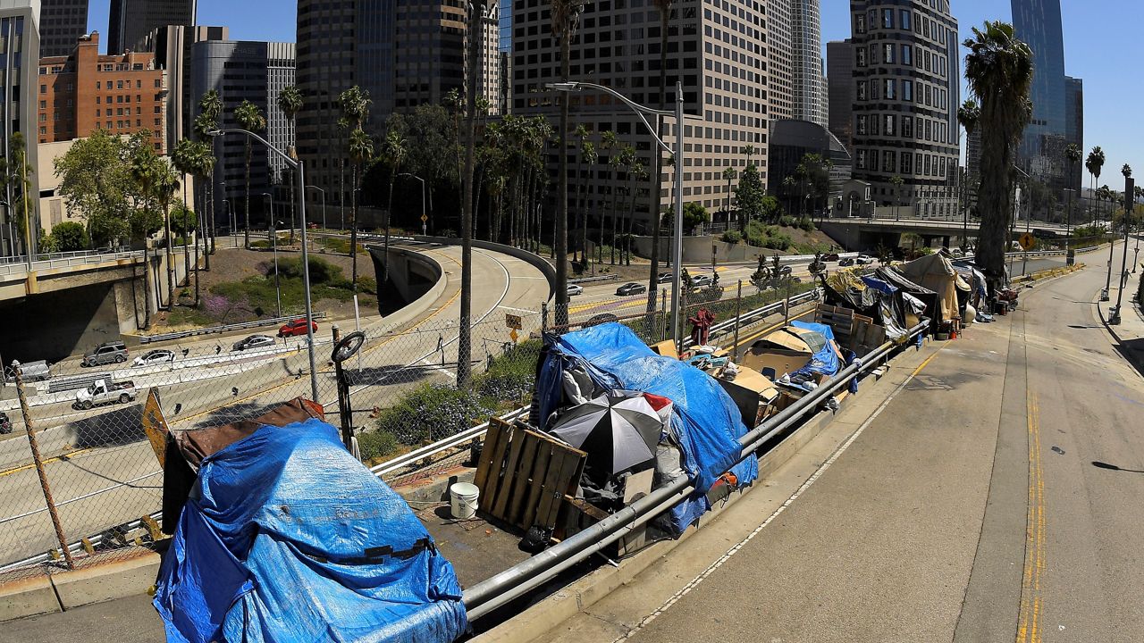 This May 21, 2020, file photo, shows a homeless encampment on Beaudry Avenue as traffic moves along Interstate 110 below during the coronavirus outbreak, in downtown Los Angeles. (AP Photo/Mark J. Terrill, File)
