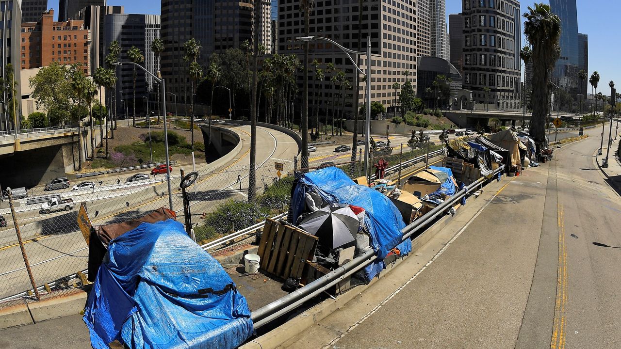 This May 21, 2020, file photo shows a homeless encampment on Beaudry Avenue as traffic moves along Interstate 110 below during the coronavirus outbreak, in downtown Los Angeles. (AP Photo/Mark J. Terrill)
