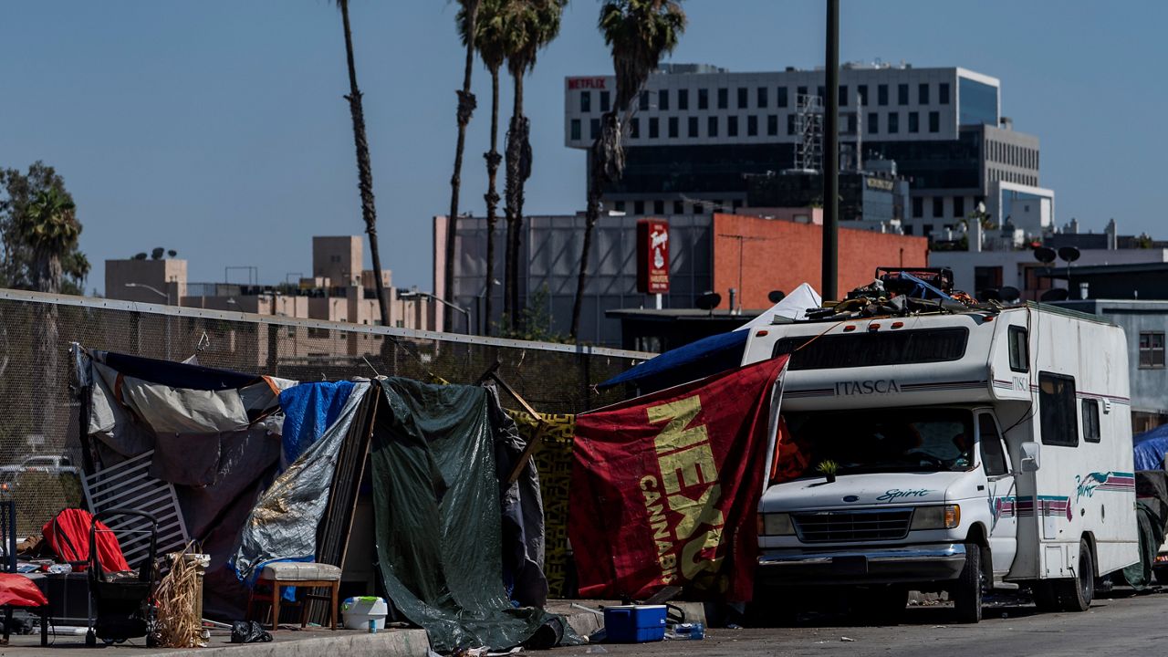 Homeless encampments installed on an overpass of the CA-101 Hollywood freeway block a sidewalk in Los Angeles Wednesday, July 7, 2021. (AP Photo/Damian Dovarganes, File)