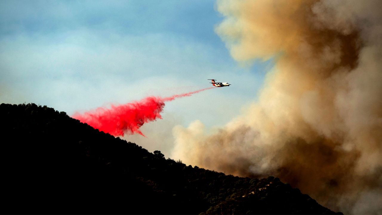 An air tanker drops retardant as the Lake Fire burns in the Angeles National Forest north of Santa Clarita, Calif., on Thursday, Aug. 13, 2020. (AP Photo/Noah Berger)