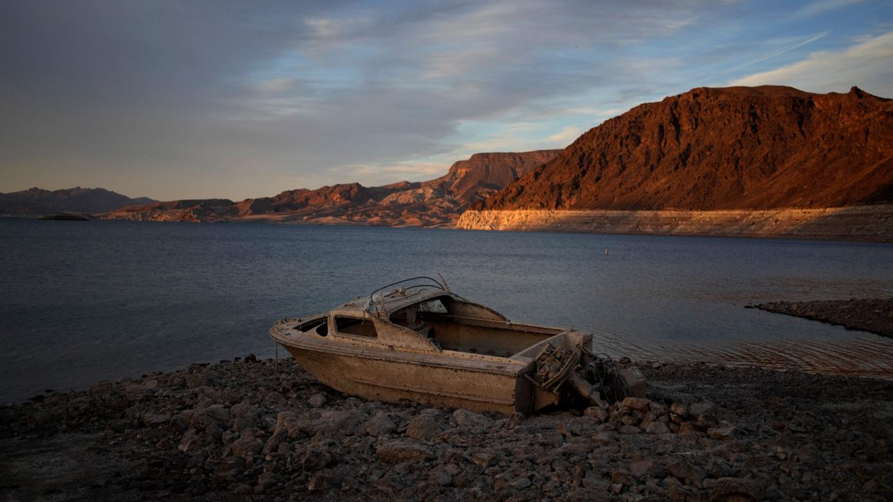 A formerly sunken boat sits high and dry along the shoreline of Lake Mead at the Lake Mead National Recreation Area, on May 10, 2022, near Boulder City, Nev. (AP Photo/John Locher, File)