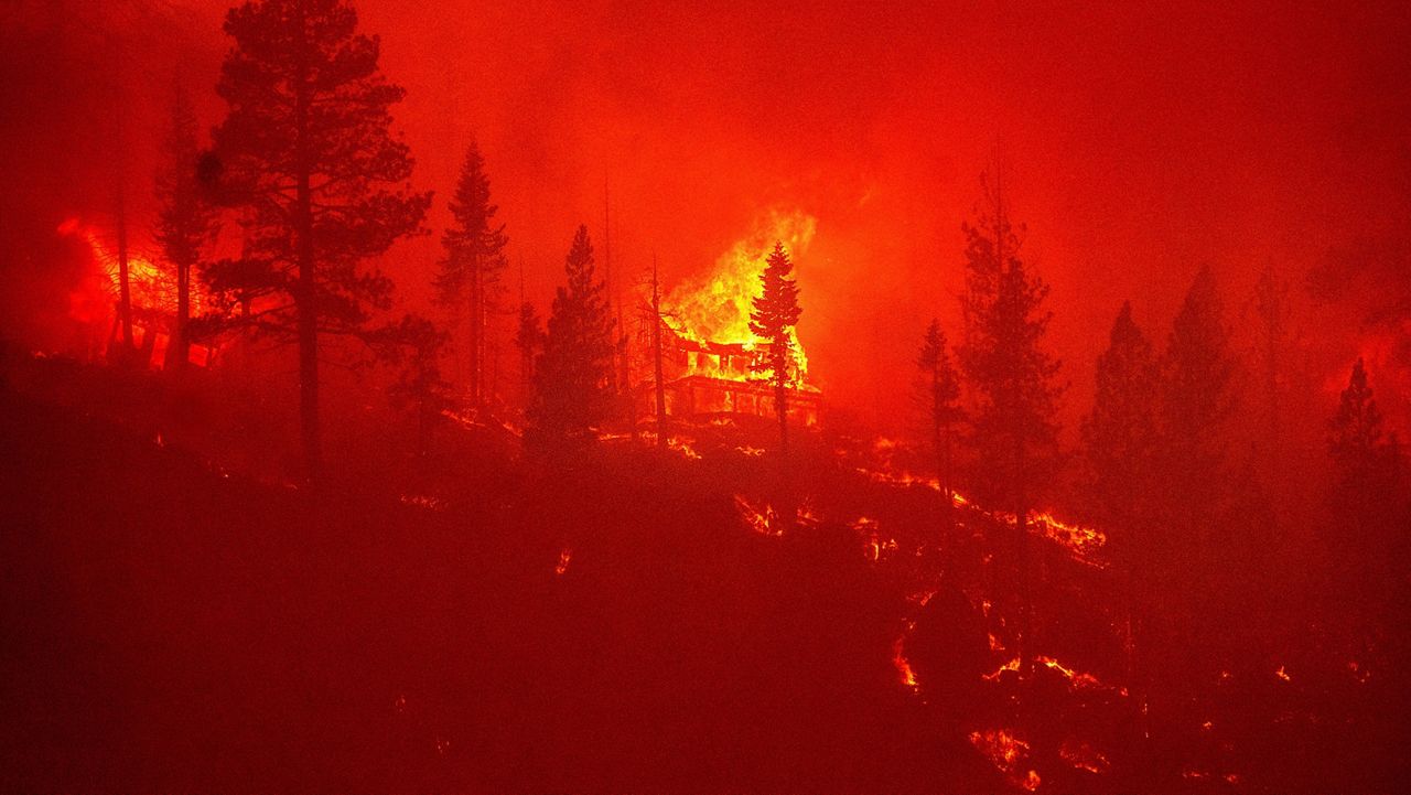 Seen from South Lake Tahoe, Calif., flames from the Caldor Fire consume a home on Monday, Aug. 30, 2021. (AP Photo/Noah Berger)