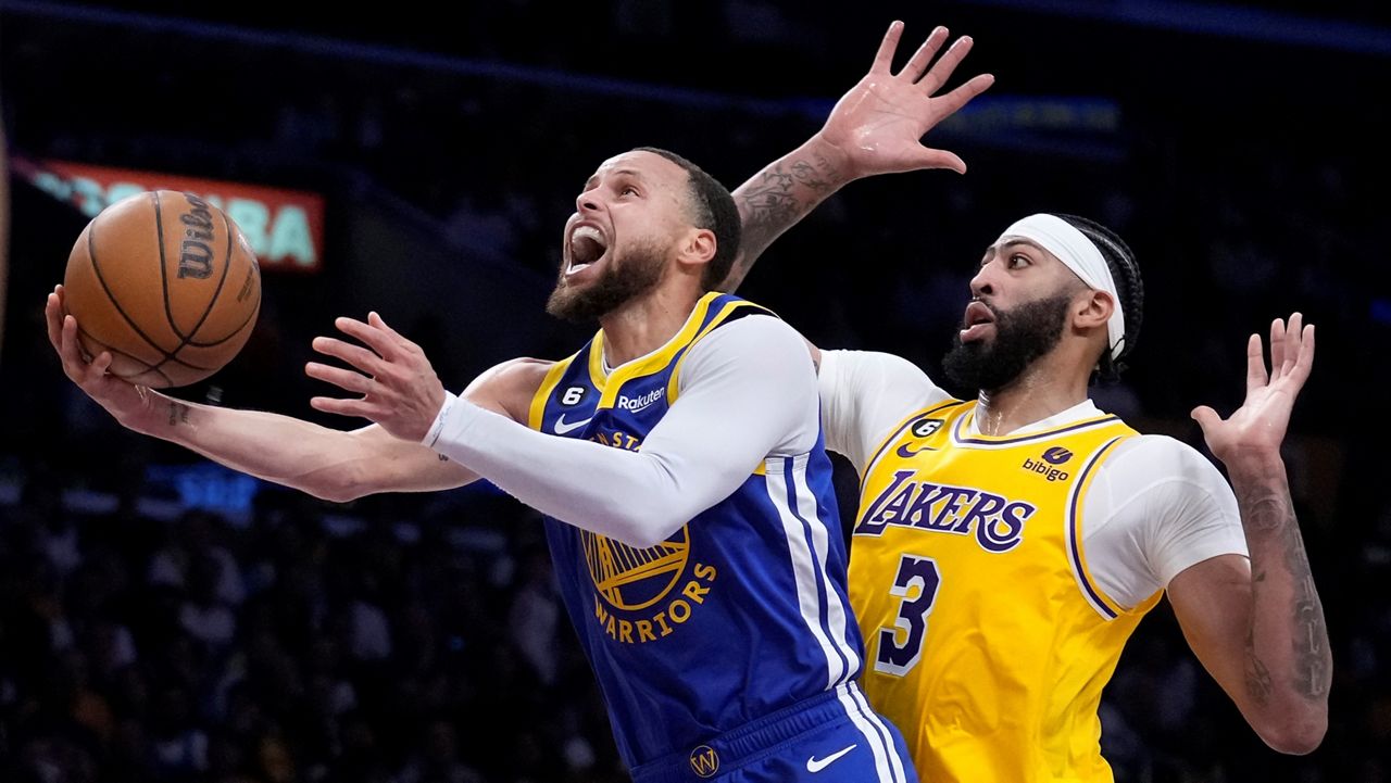 Golden State Warriors guard Stephen Curry, left, shoots as Los Angeles Lakers forward Anthony Davis defends during the first half in Game 4 of an NBA basketball Western Conference semifinal Monday in Los Angeles. (AP Photo/Marcio Jose Sanchez)