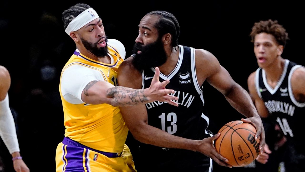 Los Angeles Lakers' Anthony Davis, left, defends Brooklyn Nets' James Harden during the first half of an NBA basketball game Tuesday, Jan. 25, 2022 in New York. (AP Photo/Frank Franklin II)