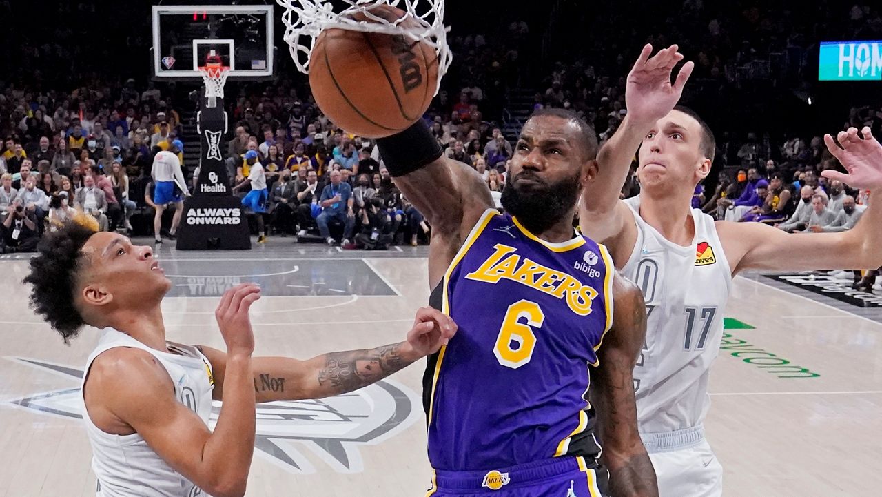 Los Angeles Lakers forward LeBron James (6) dunks between Oklahoma City Thunder guard Tre Mann, left, and forward Aleksej Pokusevski (17) during the second half of an NBA basketball game Friday, Dec. 10, 2021, in Oklahoma City. (AP Photo/Sue Ogrocki)