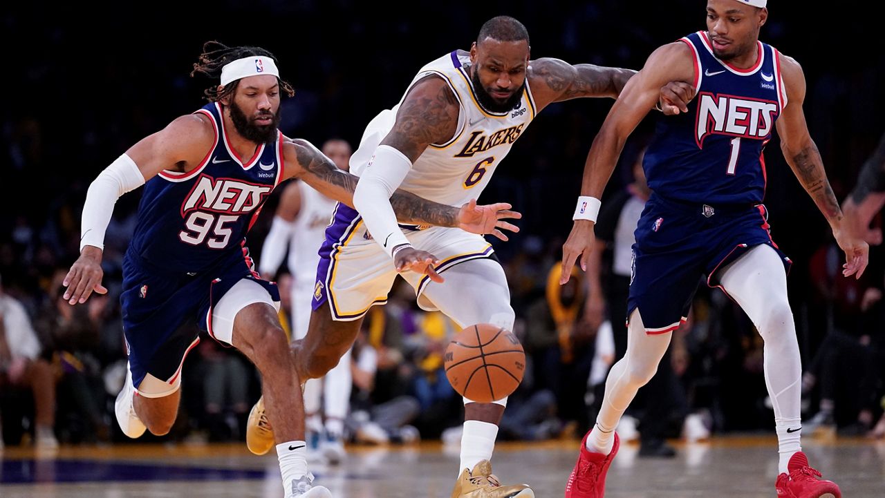 Brooklyn Nets guard DeAndre' Bembry (95) and forward Bruce Brown (1) defend against Los Angeles Lakers forward LeBron James (6) during the second half of an NBA basketball game in Los Angeles, Saturday, Dec. 25, 2021. (AP Photo/Ashley Landis)