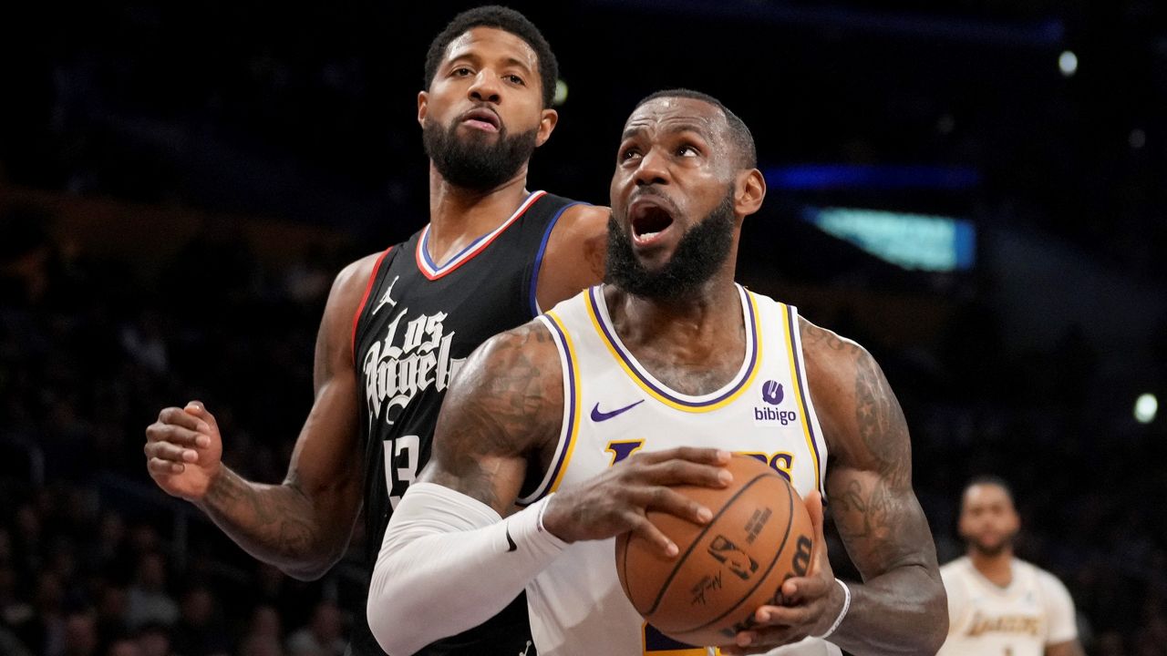 Los Angeles Lakers forward LeBron James, front right, drives to the basket against Los Angeles Clippers forward Paul George (13) during the first half of an NBA basketball game Sunday in Los Angeles. (AP Photo/Eric Thayer)