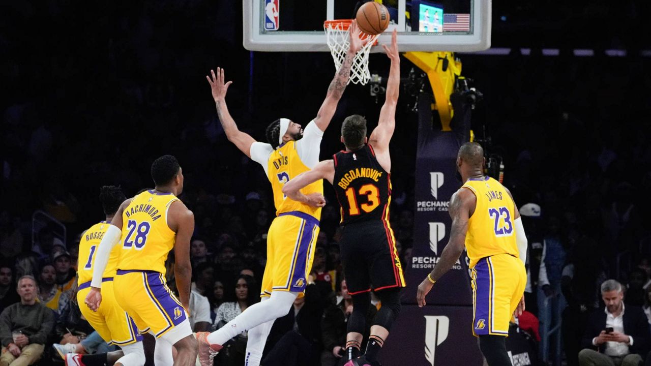 Los Angeles Lakers' Anthony Davis (3) blocks Atlanta Hawks' Bogdan Bogdanovic (13) during the first half of an NBA basketball game in LA on Monday. (AP Photo/Damian Dovarganes)