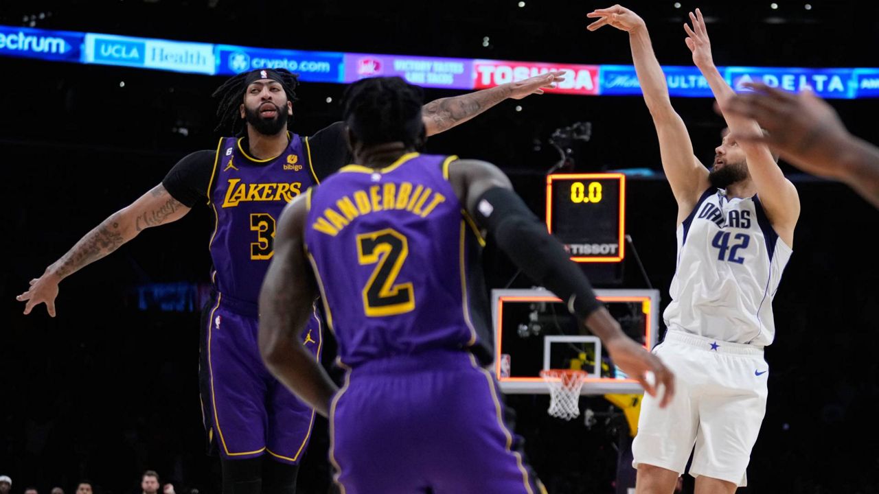 Dallas Mavericks forward Maxi Kleber (42) makes the game-winning 3-point basket over Los Angeles Lakers forward Anthony Davis (3) as time expires during the fourth quarter of an NBA basketball game Friday in LA. (AP Photo/Marcio Jose Sanchez)