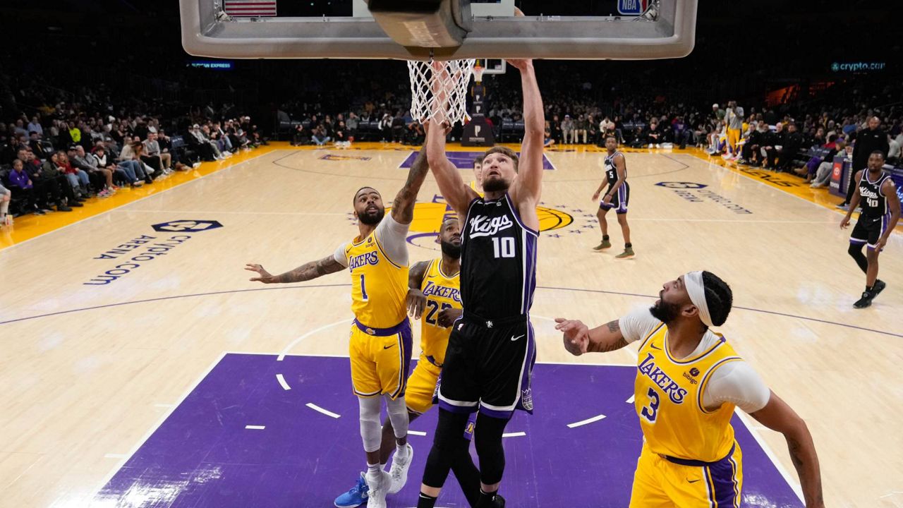 Sacramento Kings forward Domantas Sabonis (10) dunks past Los Angeles Lakers guard D'Angelo Russell (1) during the first half of an NBA basketball game Wednesday in LA. (AP Photo/Marcio Jose Sanchez)