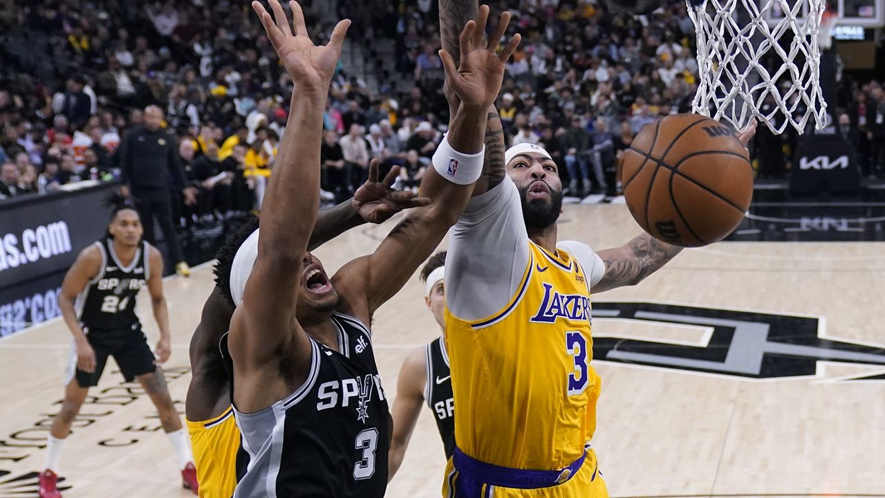 Los Angeles Lakers forward Anthony Davis (3) reacts after scoring over San Antonio Spurs center Victor Wembanyama (1) during the first half of an NBA basketball game in San Antonio, Wednesday, Dec. 13, 2023. (AP Photo/Eric Gay)