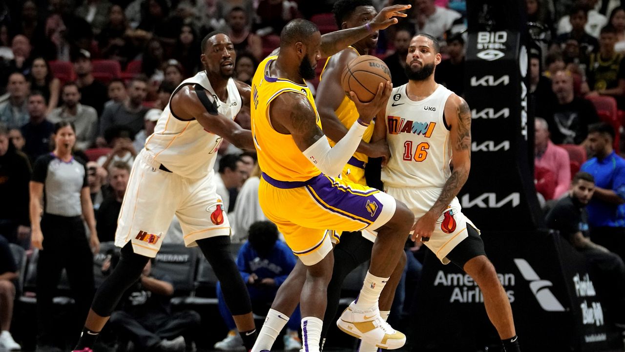 Miami Heat center Bam Adebayo, left, and forward Caleb Martin (16) defend Los Angeles Lakers forward LeBron James (6) during the first half of an NBA basketball game, Wednesday, Dec. 28, 2022, in Miami. (AP Photo/Lynne Sladky)