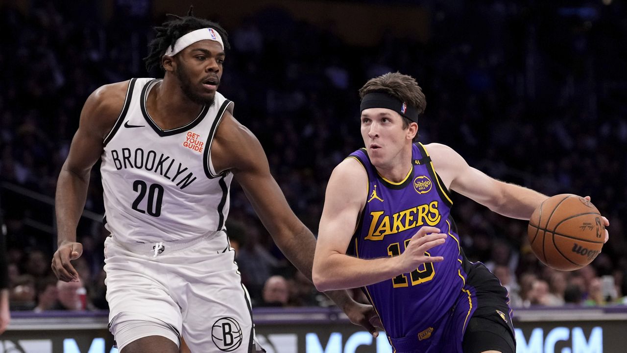 Los Angeles Lakers guard Austin Reaves, right ,drives toward the basket as Brooklyn Nets center Day'Ron Sharpe defends during the first half of an NBA basketball game, Friday, Jan. 17, 2025, in Los Angeles. (AP Photo/Mark J. Terrill)