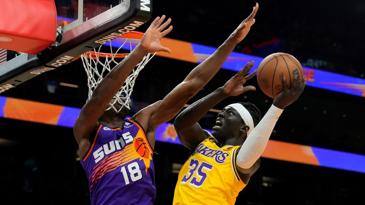 Los Angeles Lakers forward Wenyen Gabriel (35) drives against Phoenix Suns center Bismack Biyombo during the first half of an NBA basketball game, Monday, Dec. 19, 2022, in Phoenix. (AP Photo/Rick Scuteri)