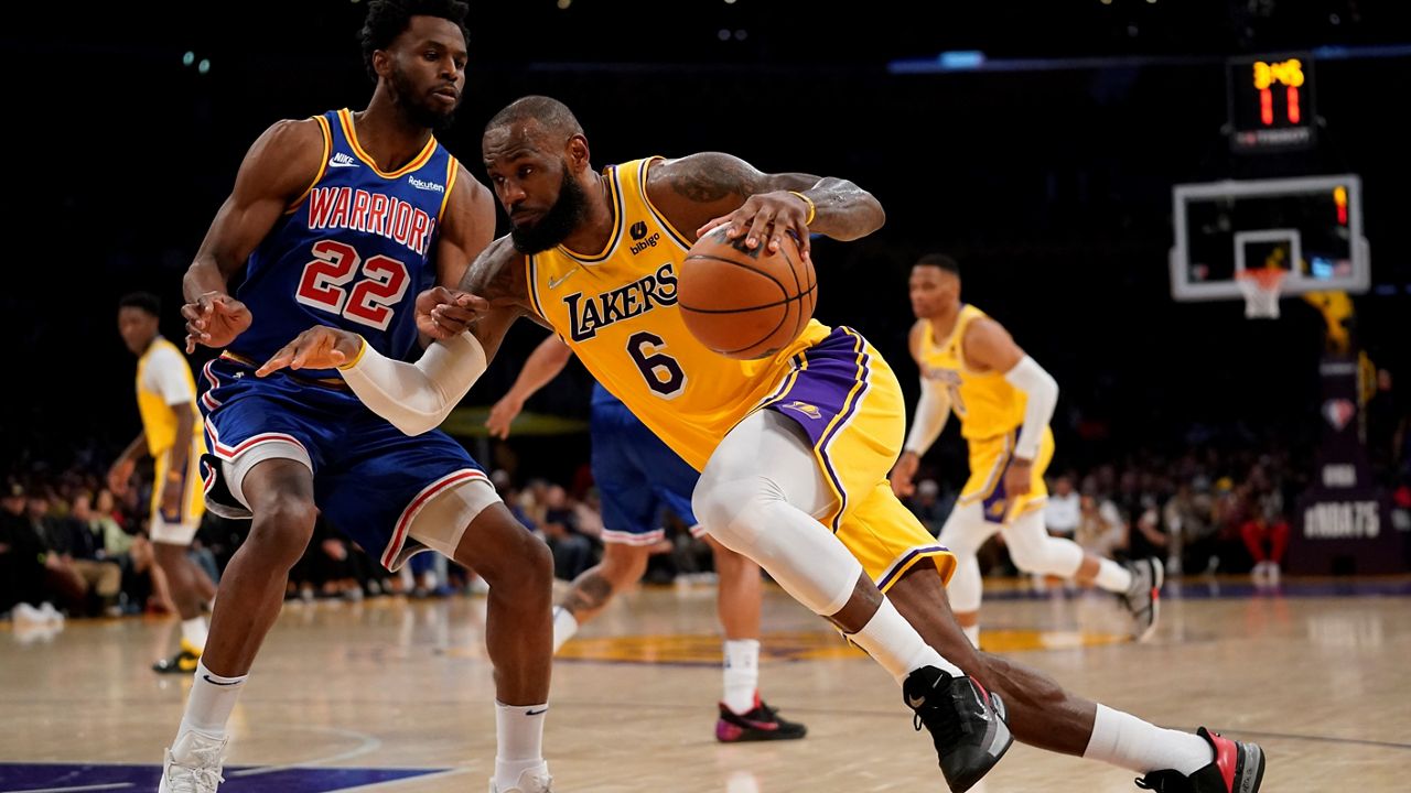 Los Angeles Lakers forward LeBron James (6) drives against Golden State Warriors forward Andrew Wiggins (22) during the first half of an NBA basketball game in Los Angeles, Saturday, March 5, 2022. (AP Photo/Ashley Landis)