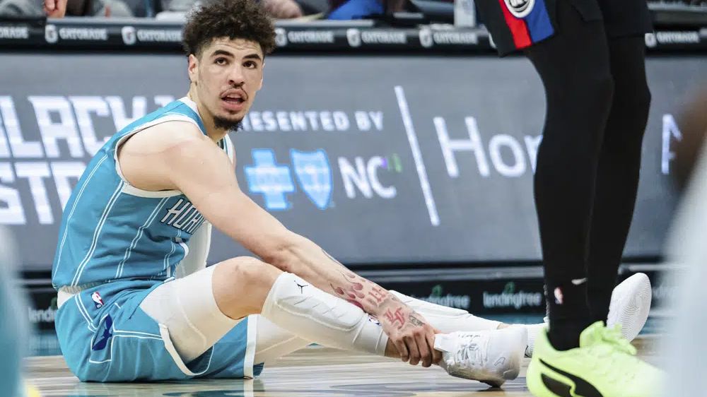 Charlotte Hornets guard LaMelo Ball holds his ankle after being shaken up on a play during the second half of an NBA basketball game against the Detroit Pistons in Charlotte, N.C., Monday, Feb. 27, 2023. (AP Photo/Jacob Kupferman)