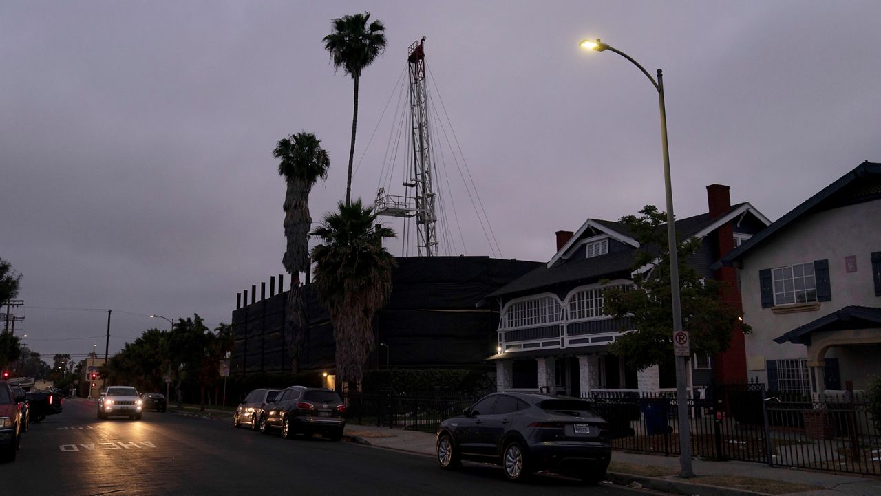 A vehicle drives past the Jefferson oil drill site located in the residential area in Los Angeles, June 2, 2021. (AP Photo/Jae C. Hong, File)