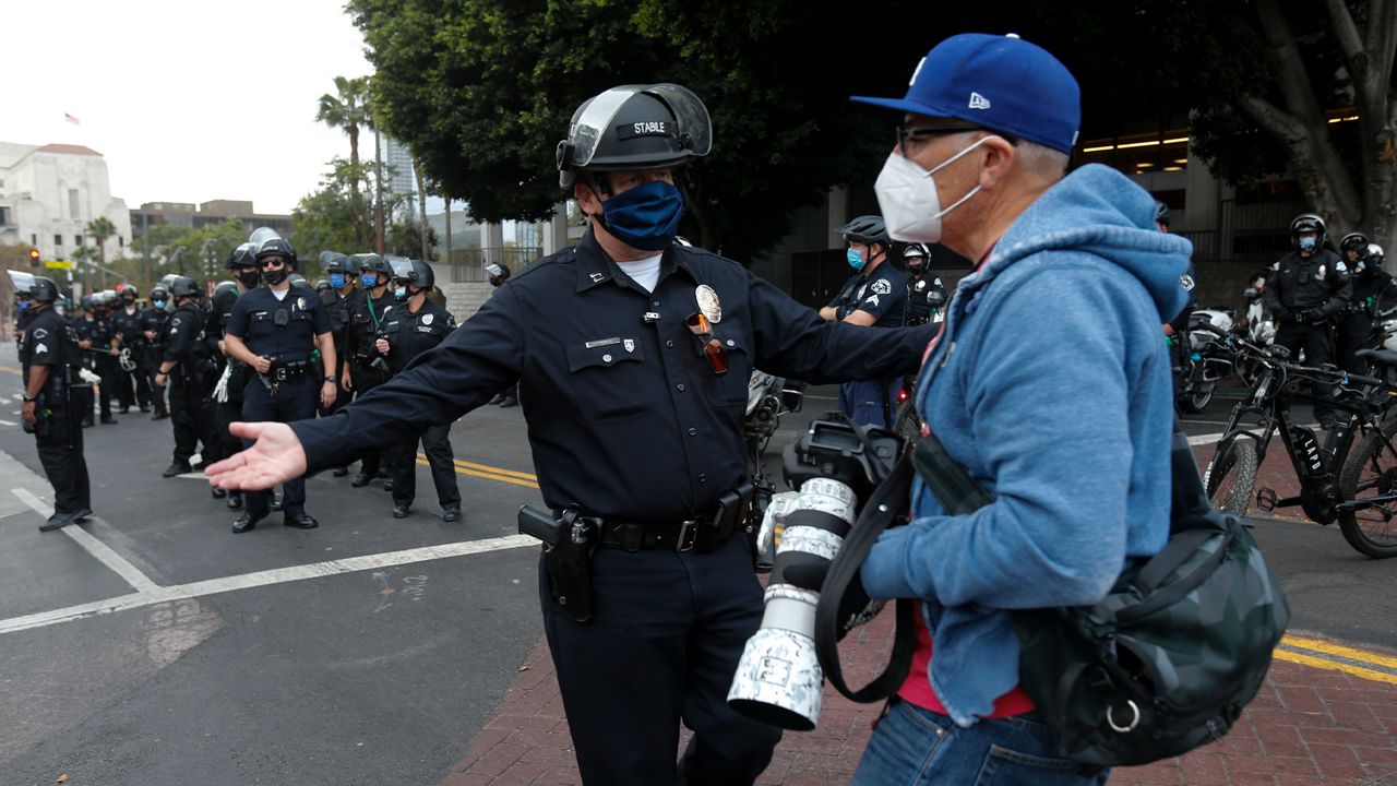 Police officers move people back during a protest after the Nov. 3 elections, Nov. 6, 2020, in Los Angeles. (AP Photo/Ringo H.W. Chiu)