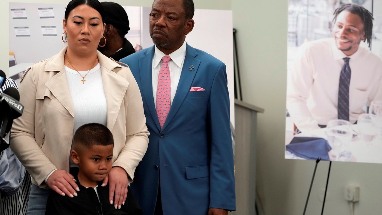 Lawyer Carl Douglas, right, holds a news conference with Gabrielle Hansel, guardian of five-year-old Syncere Kai Anderson, to announce filing a $50 million in damages claim against the city of Los Angeles over the death of Keenan Anderson, seen photo right, at a news conference in Los Angeles Friday, Jan. 20, 2023.  (AP Photo/Damian Dovarganes)