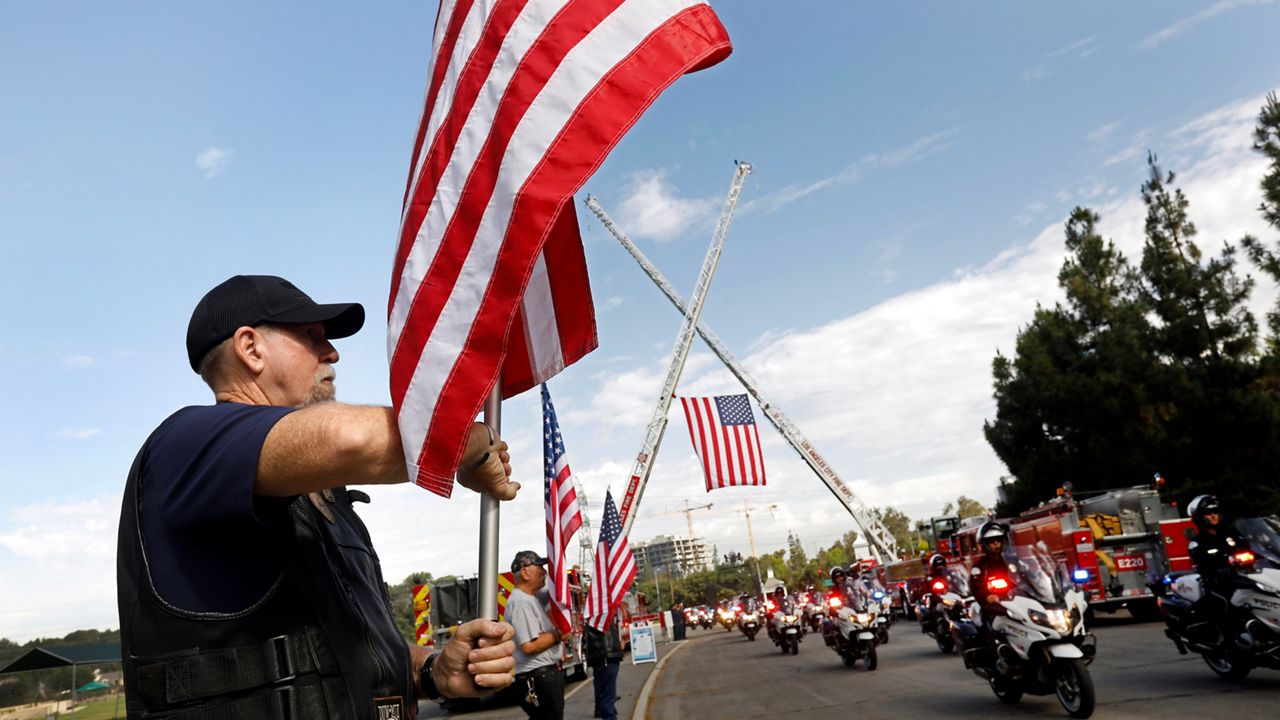 Tom Parry, left, and other members of the Patriot Guard Riders stand at attention as the family of LAPD Officer Houston R. Tipping arrive at his memorial service at Forest Lawn Hollywood Hills in Los Angeles. (Carolyn Cole/Los Angeles Times via AP)