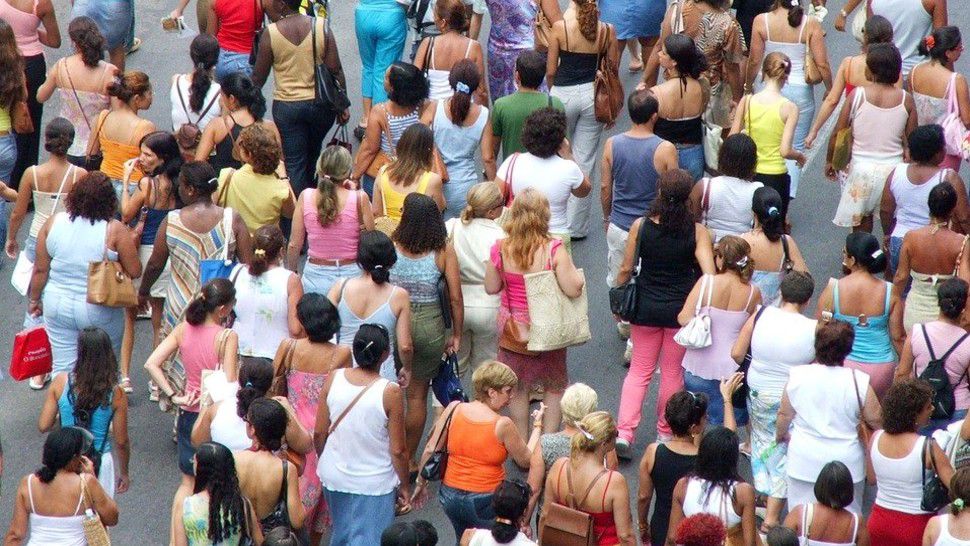 A crowd of people moves along in an urban area in this stock image. (Pixabay)