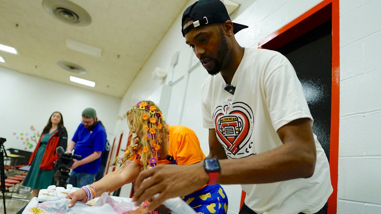 JCPS bus driver Larry Farrish sorts through packages of pajamas before handing them to students at Engelhard Elementary (Spectrum News 1/Mason Brighton)