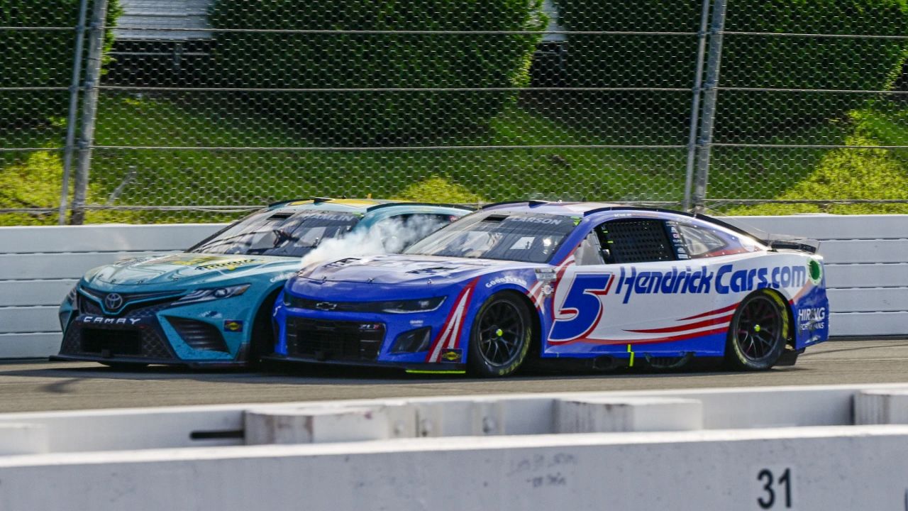 Kyle Larson (5) rubs fenders with Denny Hamlin (11) under caution during a NASCAR Cup Series auto race at Pocono Raceway, Sunday, July 23, 2023, in Long Pond, Pa. (AP Photo/Derik Hamilton)