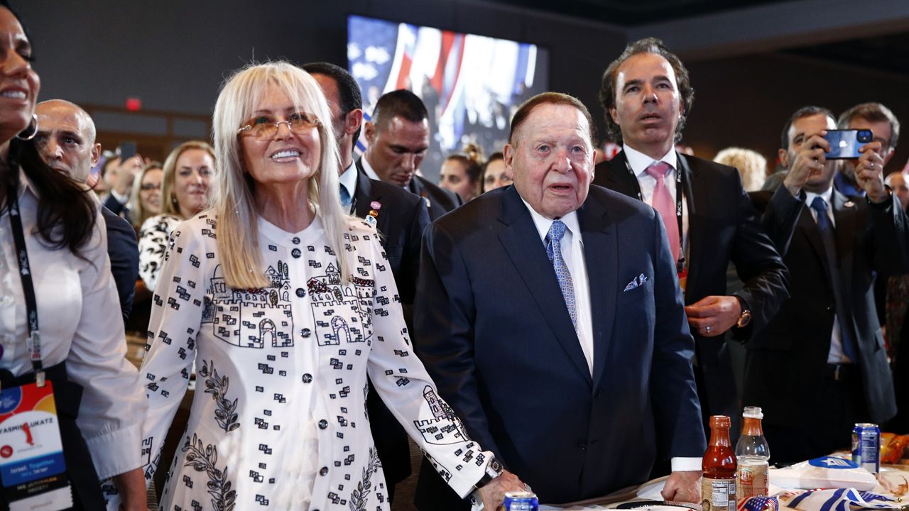 Las Vegas Sands Corporation Chief Executive and Republican mega donor Sheldon Adelson, center, and his wife, Miriam Adelson, left, listen as President Donald Trump speaks at the Israeli American Council National Summit in Hollywood, Fla., Saturday, Dec. 7, 2019. Miriam Adelson, the controlling shareholder of casino company Las Vegas Sands Corp., plans to sell $2 billion in company stock and buy an unspecified professional sports franchise, the company announced Tuesday, Nov. 28, 2023. Dallas Mavericks owner Mark Cuban is working on a deal to sell a majority stake in the NBA franchise to the Adelson family, a person with knowledge of the talks said late Tuesday. (AP Photo/Patrick Semansky, File)  Date:	Nov 29, 2023 5:04 PM Slug:	Mavericks Ownership Basketball Headline:	Mavericks Ownership Basketball Source:	AP Notes:	FILE PHOTO