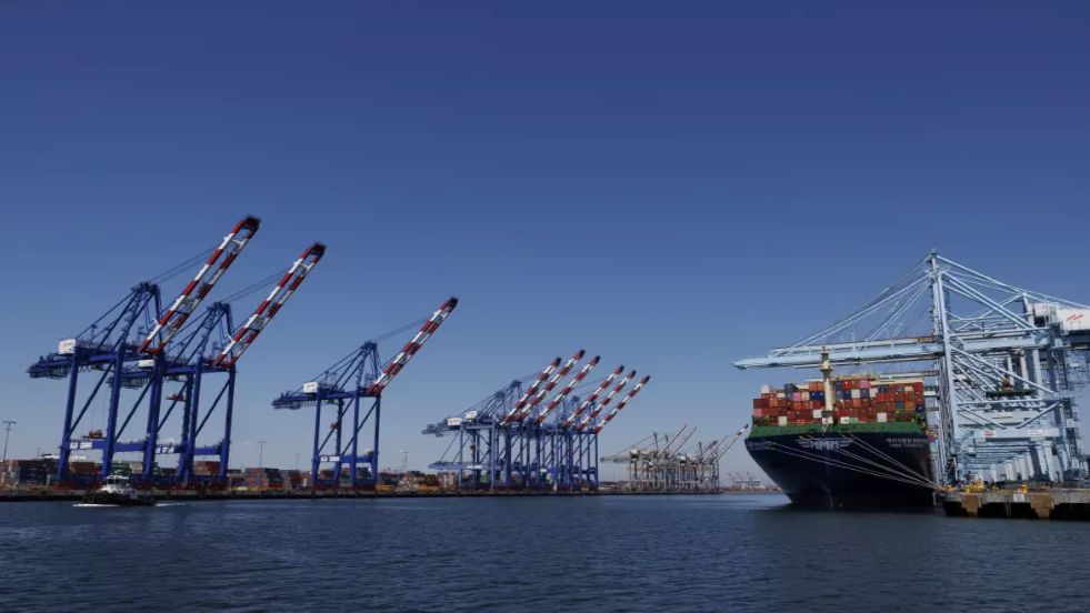Cargo is loaded onto a container ship on the right while the normally bustling berths sit empty. (Los Angeles Times/Gina Ferazzi)