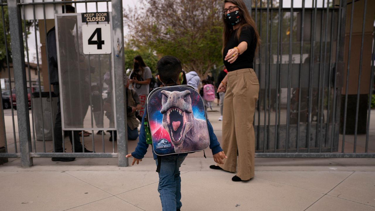 Kindergartener Angel Hernandez leaves after the first day of in-person learning at Maurice Sendak Elementary School in Los Angeles, Tuesday, April 13, 2021. (AP Photo/Jae C. Hong)