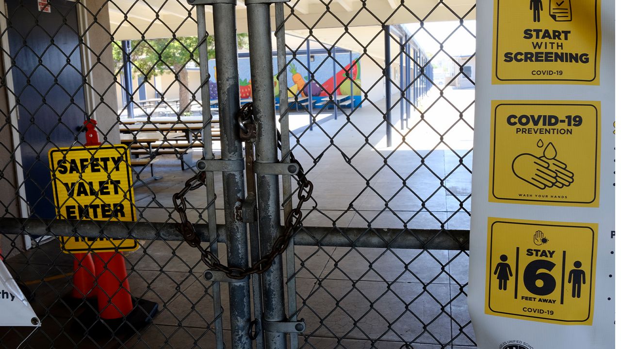 A chain link fence lock is see on a gate at a closed Ranchito Elementary School in the San Franando Valley section of Los Angeles on Monday, July 13, 2020. Amid spiking coronavirus cases, Los Angeles Unified School District campuses will remain closed when classes resume this August, Superintendent Austin Beutner said Monday.(AP Photo/Richard Vogel)