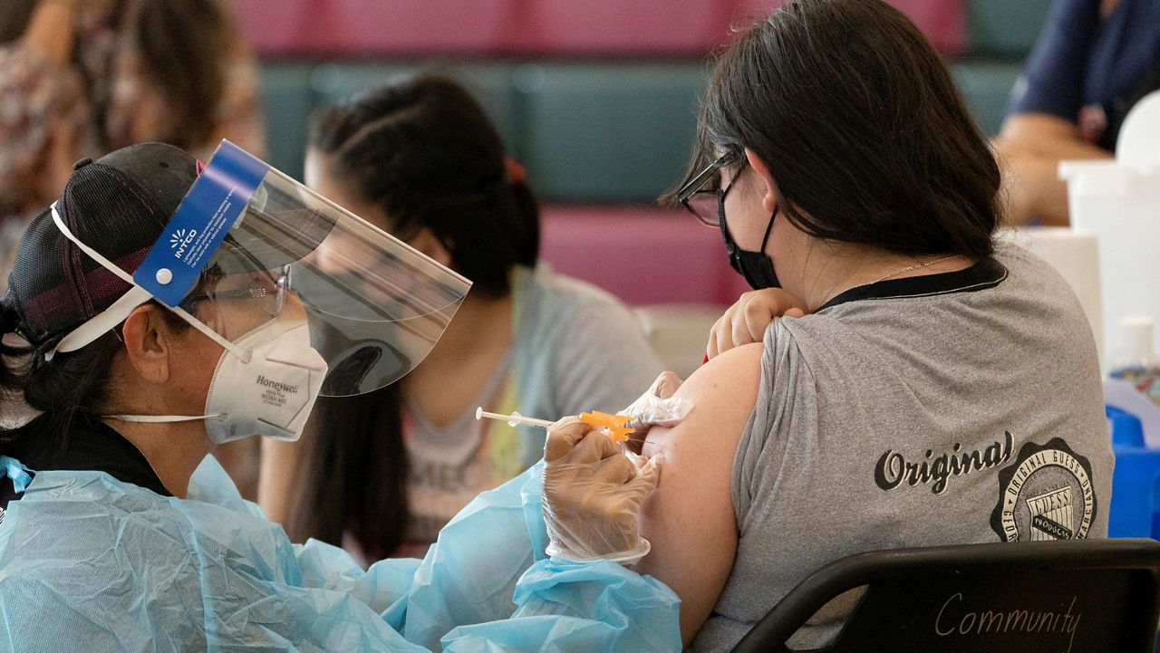 A 15-year-old girl in East Los Angeles, California, gets vaccinated with Pfizer's COVID-19 vaccine on May 27, 2021. (AP Photo/Damian Dovarganes, File)