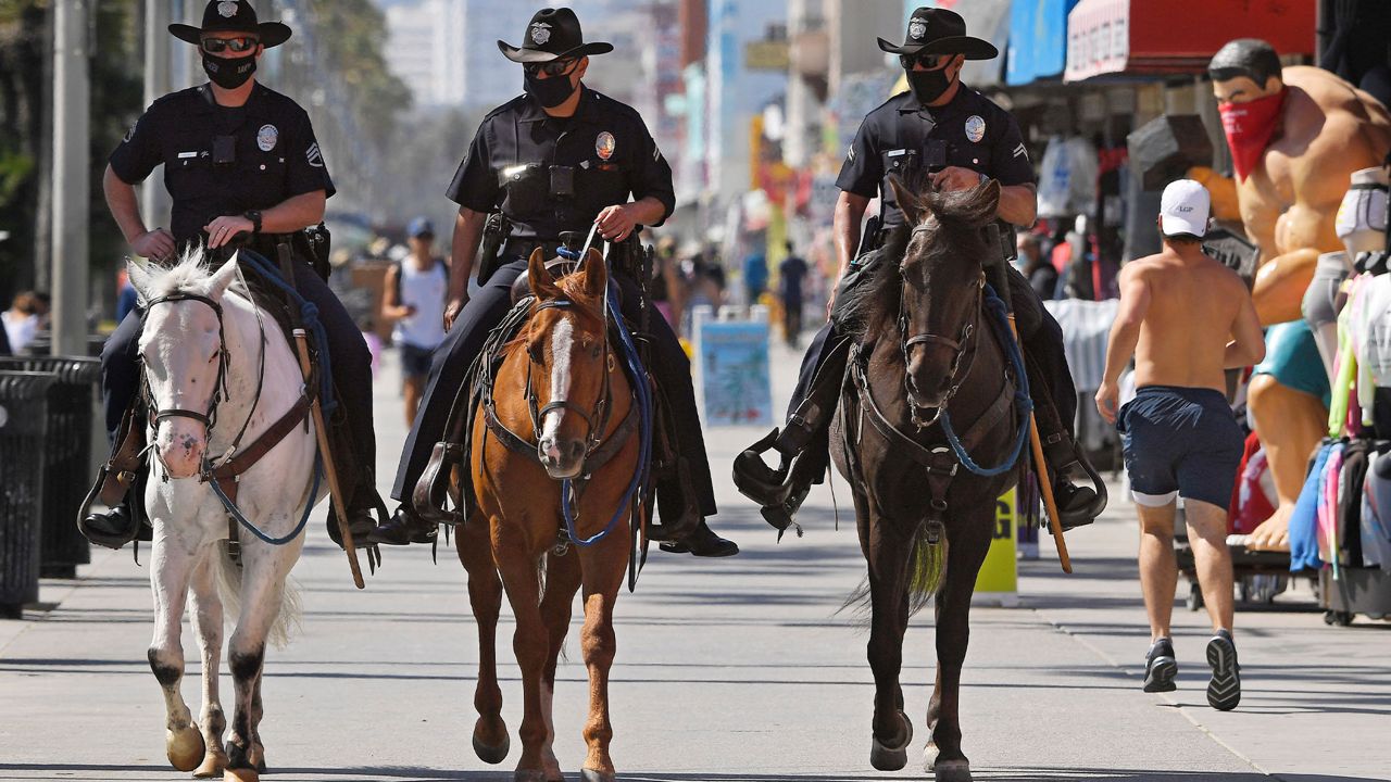 Los Angeles police officers patrol the Venice Beach boardwalk on horseback during the coronavirus outbreak, Wednesday, May 13, 2020, in Los Angeles. (AP Photo/Mark J. Terrill)
